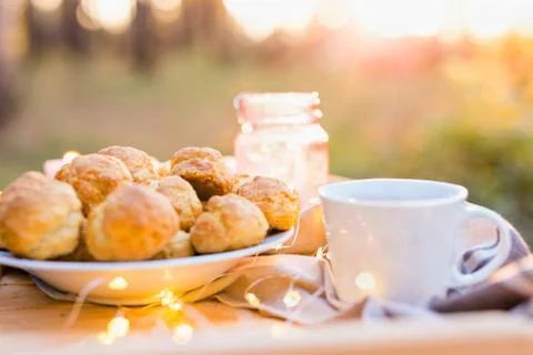 Coffee table setting with coffee cup, cookies at sunset Stock Photos