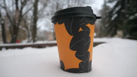 Coffee in a takeaway glass in the snow. Coffee and winter Stock Footage 262262953