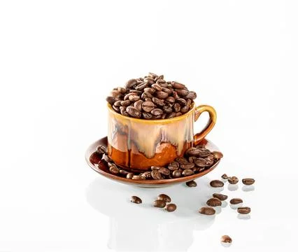 Coffee theme. A ceramic cup filled to the brim with coffee beans stands on a Stock Photos