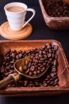 Coffee theme. Hot cups of coffee and plate with coffee beans on black wooden Stock Photos