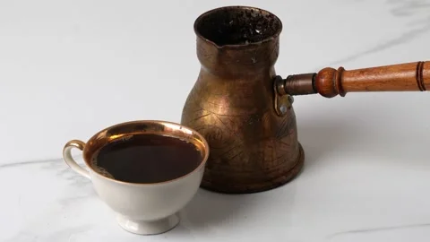 Coffee in a white cup about a coffee pot on a light background Stock Footage 169792894
