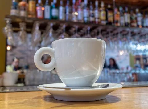 Coffee white cup on brown table and blurred background with people relaxing Stock Photos
