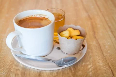 Coffee in white cup on disk with small cookies Stock Photos
