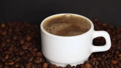 Coffee in a white mug with steam on the background of grains Video stock 229970531