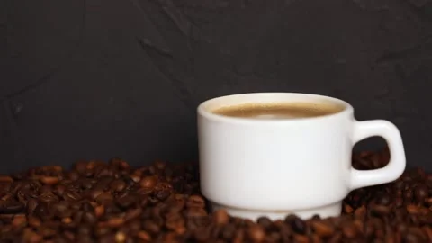 Coffee in a white mug with steam on the background of grains Video stock 233499501