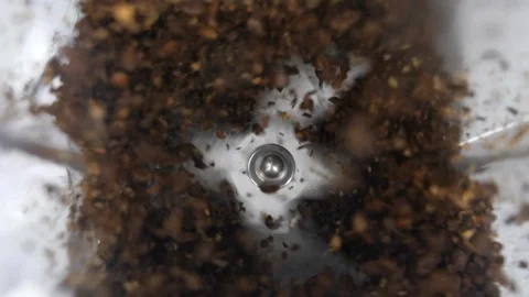Coffee in a working grinder with blades blending individual beans  from above Stock Footage 88514815