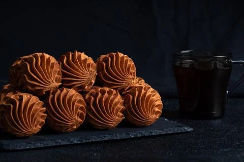 Coffee Zephyr accompanied by elegantly designed pastries on a dark slate surf Stock Photos