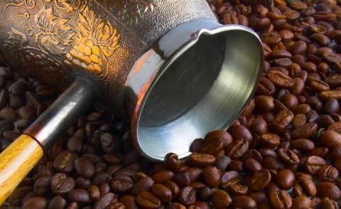 The coffeepot lying on the coffee beans Stock Photos