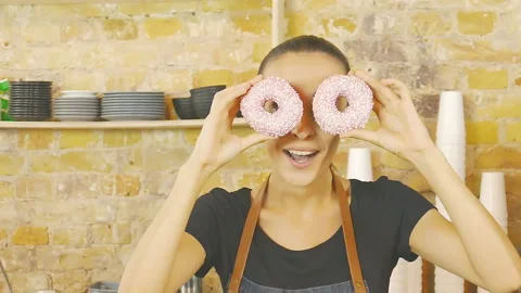 Coffeeshop worker have fun with donats. Slow motion. Stock Footage 95388480