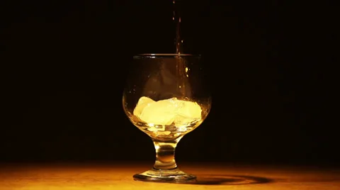 Cognac, brandy with ice is poured Stock Footage 34434428