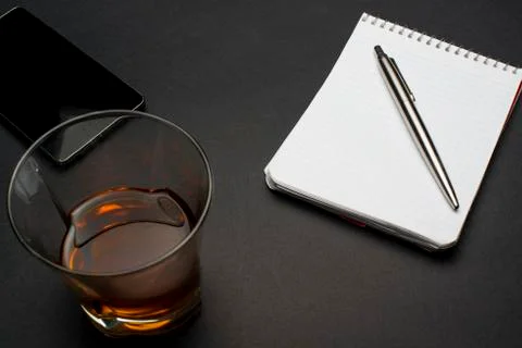 Cognac notepad  pen on a black table 스톡 사진