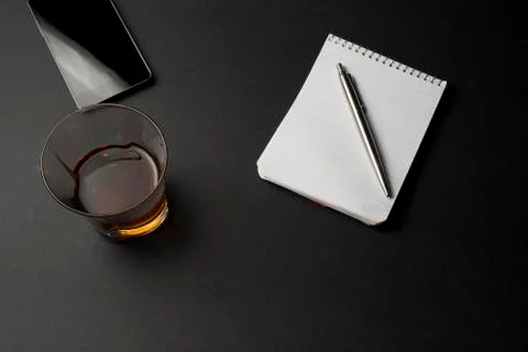 Cognac notepad  pen on a black table Stock Photos