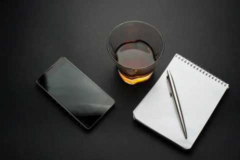 Cognac notepad  pen on a black table Stock Photos