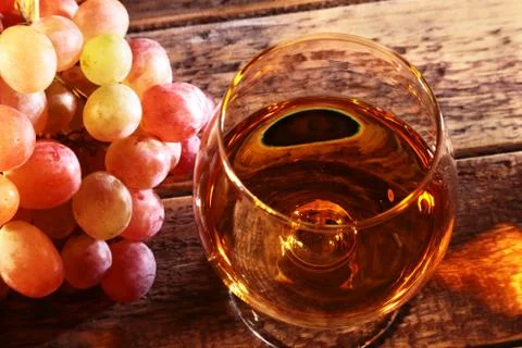 Cognac or Brandy in a glass and fresh grapes, still life in rustic style Stock Photos