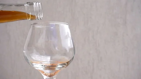 Cognac is poured into an empty glass from the bottle in slow motion Stock-Footage 112946467