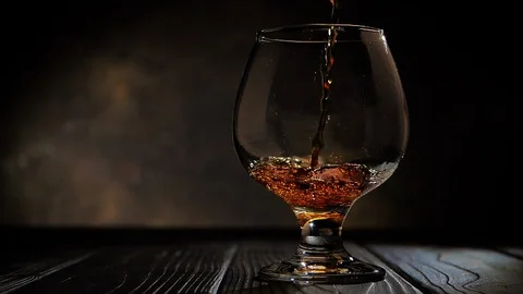 Cognac is poured into a glass. On dark background. Stock Footage 105160186