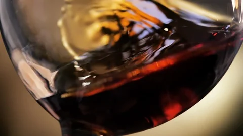 Cognac is rotated in a glass. On dark background. Stock Footage 104858989