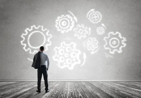 Cogwheel engine drawn on concrete wall as symbol for teamwork and cooperation Stock Photos