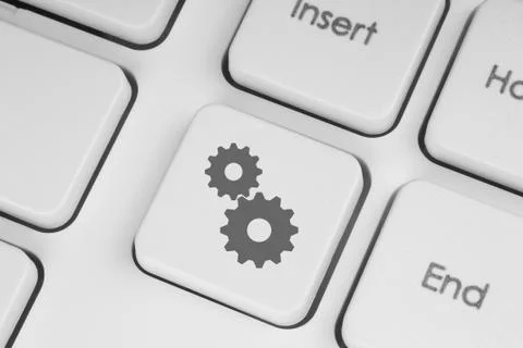 Cogwheels on white keyboard. Stock Photos