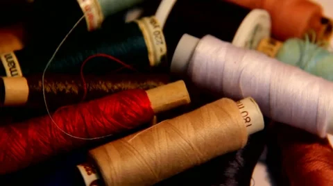 Coil and bobbin with colored thread, scattered on a white table - slow motion. Stock Footage 44326138