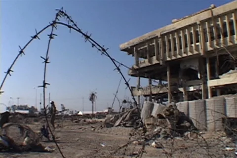 Coil of barbed wire in front of bombed building. Stock Footage 86753693