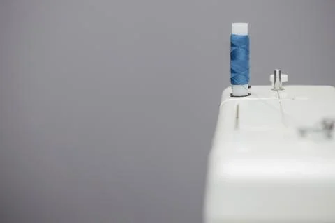 Coil with blue threads installed on a sewing machine Stock Photos