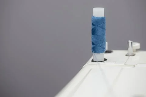 Coil with blue threads installed on a sewing machine Stock Photos