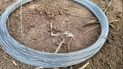 Coil of galvanized steel wire on the ground Stockbeeldmateriaal 325416366