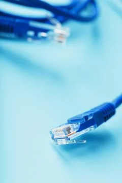 A coil of an Internet network cable for data transmission on a blue backgroun Stock Photos