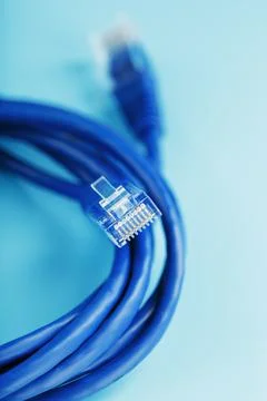 A coil of an Internet network cable for data transmission on a blue background Stock Photos