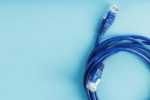 A coil of an Internet network cable for data transmission on a blue background Stock Photos
