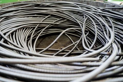 A coil of iron wire is shot close-up, a flexible spring in a long hose. Man.. Stock Photos