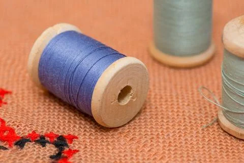 Coil thread on the canvas. Multicolored thread. Wooden coils. Stock Photos
