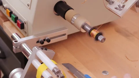 Coil winding machine reeling conducting wire on plastic support, close up 動画素材 140114918