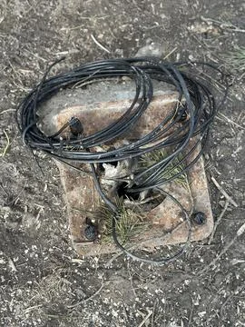 Coiled Black Electric Cable on Ground Outdoors Stock Photos