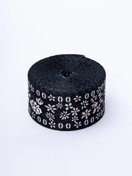 Coiled black floral pattern trim ribbon Stock Photos