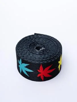 Coiled black webbing strap with colorful leaf pattern Stock Photos