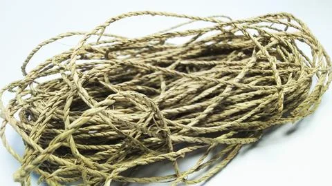Coiled bundle of natural jute twine rope on a white background. Stock-Fotos