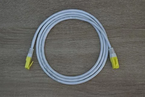 Coiled Ethernet network cable on wooden background Stock Photos