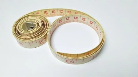 A coiled measuring tape on a white background. Stock Photos