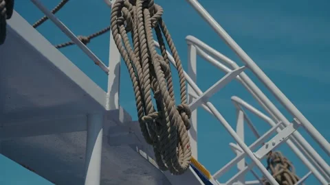 Coiled Nautical Rope Hanging On White Ship Railing Against Blue Sky Stock Footage 337914026