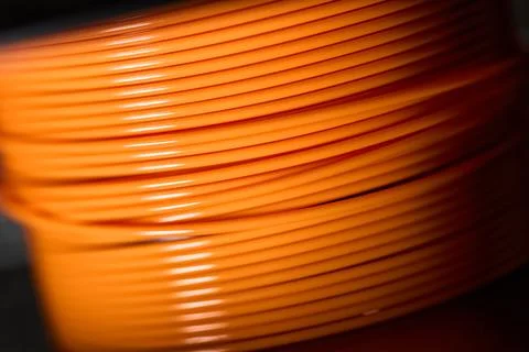 Coiled orange wire on dark background Stock Photos