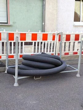 A coiled piece of corrugated pipe for cable or drainage enclosed by a Stock-Fotos