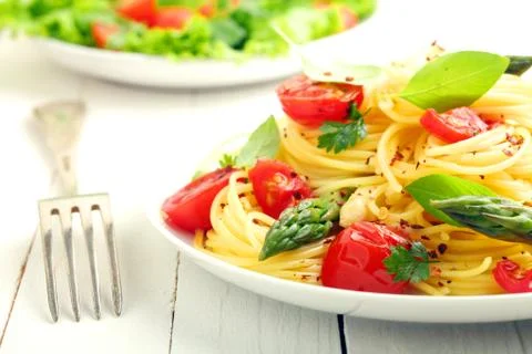 Coiled spaghetti with tomato and basil Stock Photos
