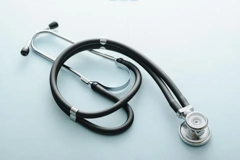 Coiled stethoscope on a blue background Stock Photos