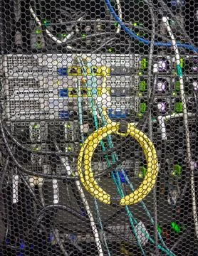 Coiled yellow cable connecting digital equipmnet installed in a rack Stock Photos