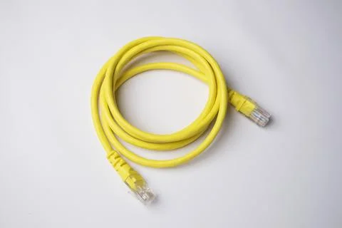 Coiled yellow Ethernet patch cable with RJ45 connectors on both ends, isola.. Stock Photos