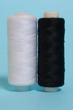Coils with black and white threads on a blue background Stock Photos