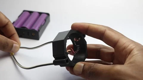 Coils of nichrome wire gets red hot when connected to battery power Video stock 298474250