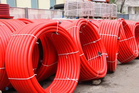Coils of red cable stored at a construction site, repair work, building mater Stock Photos
